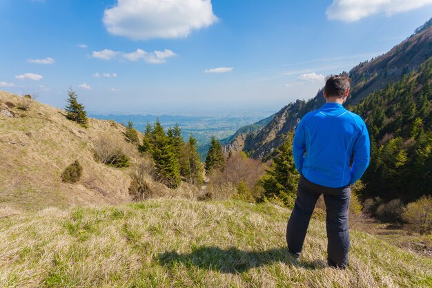 Człowiek na szczycie góry patrząc na horyzont. Panorama gór