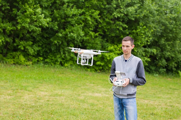 Człowiek obsługujący drona latający lub unoszący się przez pilota w naturze