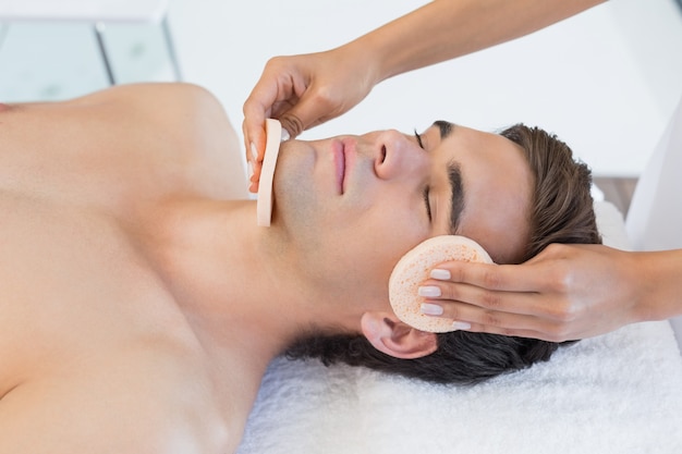 Człowiek odbiera masaż twarzy w centrum spa