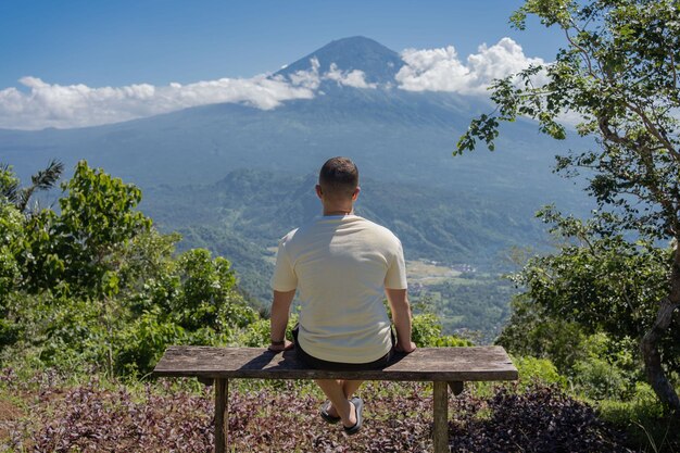 Zdjęcie człowiek patrzący na wulkan agung w indonezji wyspa bali piękny krajobraz wulkanu