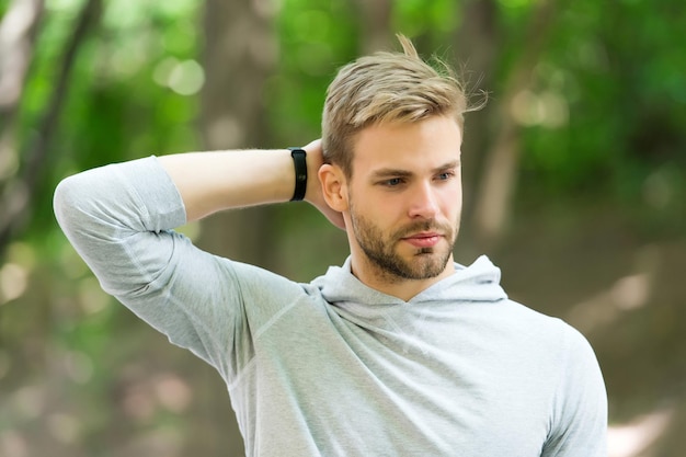 Człowiek pewny swojego antyperspirantu. Facet sprawdza suchą pachę zadowoloną z czystych ubrań. Sportowiec po treningu zadowolony z antyperspirantu. Zapobiegaj, zmniejsz pocenie się. Bez potu - dezodorant działa.