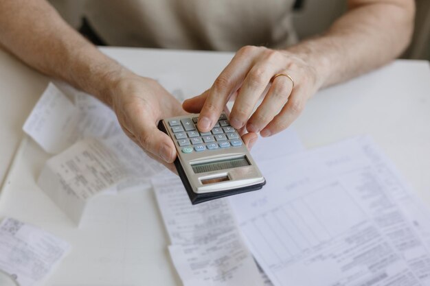 Człowiek płaci rachunki i media liczy kwotę wydatków i dochodów na kalkulatorze Znajomość finansów i płatności hipotecznych lub czynszowych