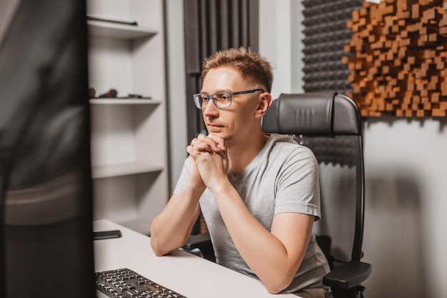 Człowiek pracujący w studiu muzycznym przy użyciu komputera w okularach Inżynier dźwięku pracujący i miksujący utwór Programista oglądający go na wyświetlaczu podczas słuchania muzyki Koncepcja technologii