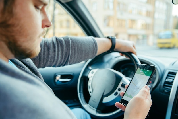 Człowiek Ręce Na Kierownicy Przy Użyciu Telefonu Jako Nawigatora. Podróż Samochodem