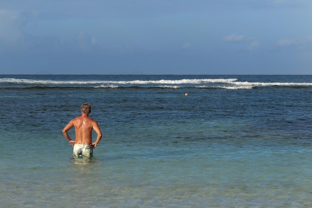 Człowiek samotny na tropikalnym morzu pod błękitnym niebem