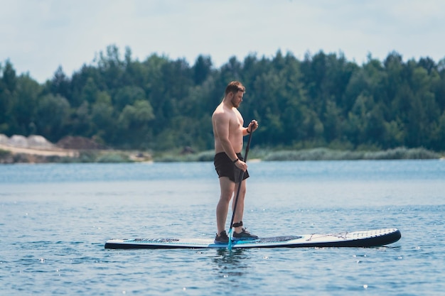 Człowiek stojący na desce w środku jeziora letnie zajęcia wodne