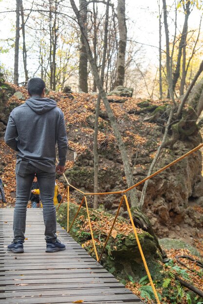 Zdjęcie człowiek stojący na drewnianym moście w lesie