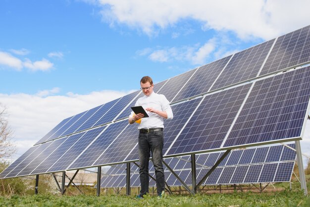 Człowiek stojący w pobliżu paneli słonecznych Panel słoneczny produkuje zieloną, przyjazną dla środowiska energię słoneczną