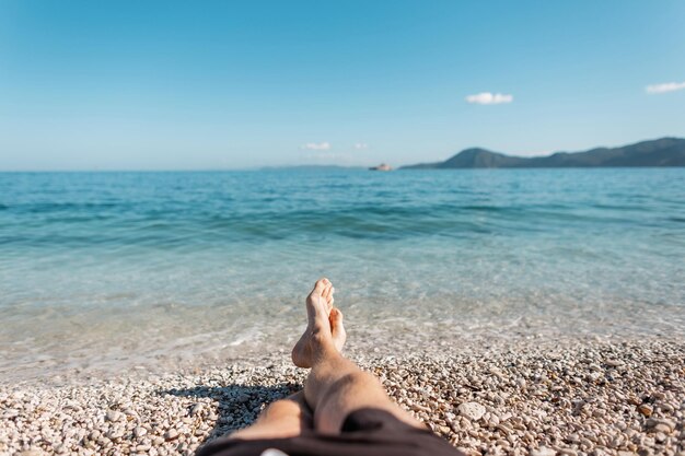 Człowiek sukcesu leży na plaży w pobliżu błękitnego, czystego morza z niebem na wyspie Elba Włochy Letnie wakacje i podróże