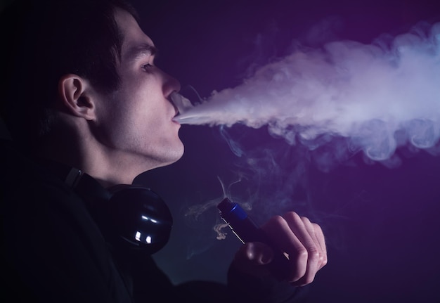 Człowiek w chmurach pary z elektronicznego papierosa zbliżenie vaping man