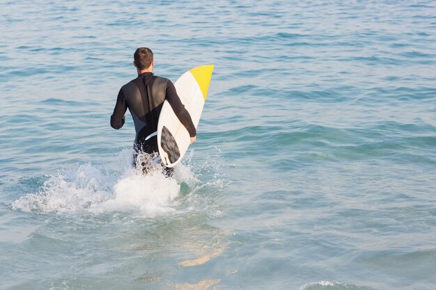 Człowiek w kombinezon z deski surfingowej w słoneczny dzień