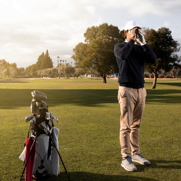 Człowiek z lornetkami na polu golfowym