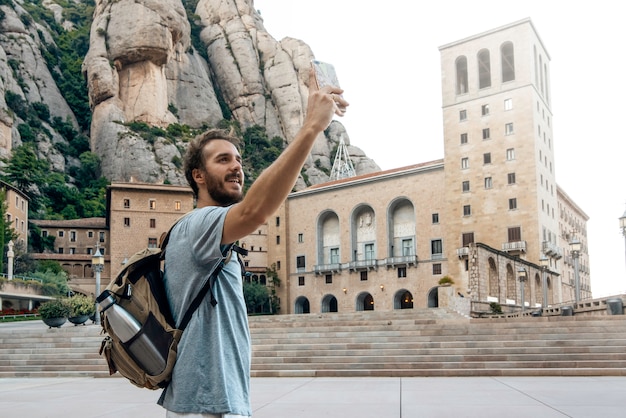 Człowiek z telefonem robiącym selfie w klasztorze montserrat, Barcelona, Hiszpania