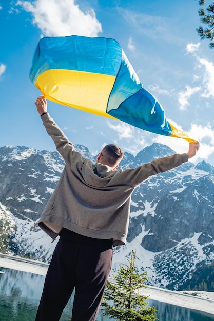 Człowiek z ukraińskim stoi na tle gór Morskie Oko