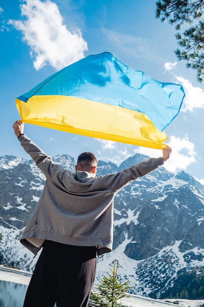 Człowiek z ukraińskim stoi na tle gór Morskie Oko