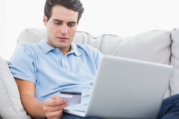 Człowiek za pomocą swojej karty kredytowej, aby dokonać zakupu przez Internet