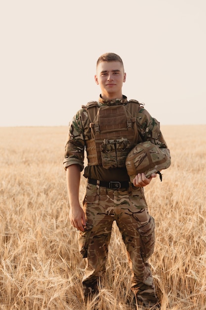 Człowiek żołnierz stojący na polu. Portret szczęśliwy żołnierza wojskowego w boot camp. Żołnierz US Army w misji. koncepcja wojny i emocji.