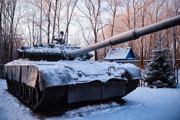 Czołg pod śniegiem w lesie Zimowy kamuflaż czołgu Czołg w śniegu na poboczu autostrady Wojna na Ukrainie zimą