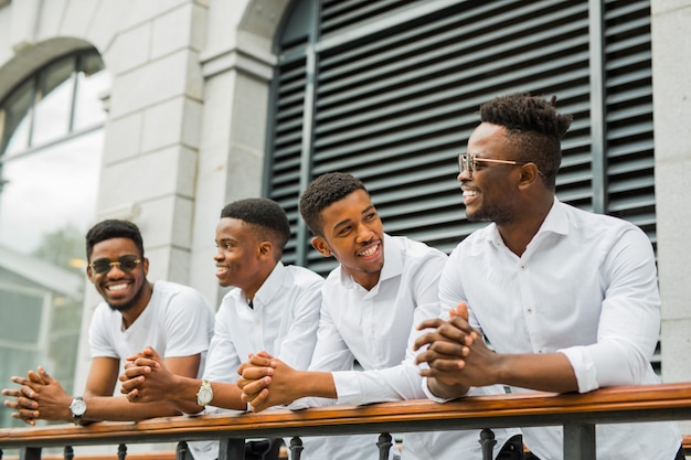 Czterech przystojnych młodych afrykańskich mężczyzn w białych koszulach