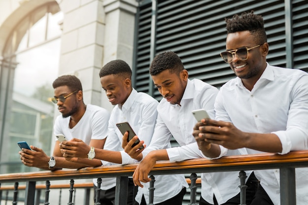 Czterech przystojnych młodych afrykańskich mężczyzn w białych koszulach