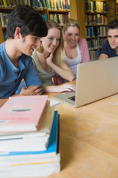 Zdjęcie czterech studentów studiujących w bibliotece