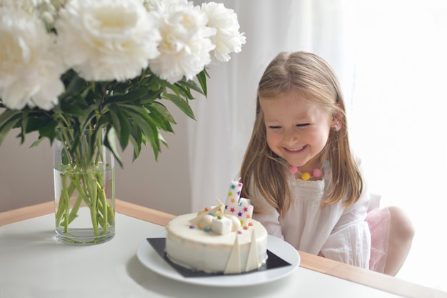 Czteroletnia dziewczynka życząca dmuchanie świec na ciasto