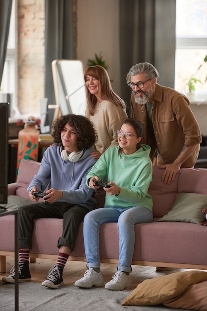 Czteroosobowa rodzina grająca razem w gry online w czasie wolnym w domu