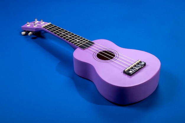 Czterostrunowa gitara ukulele na niebieskim tle