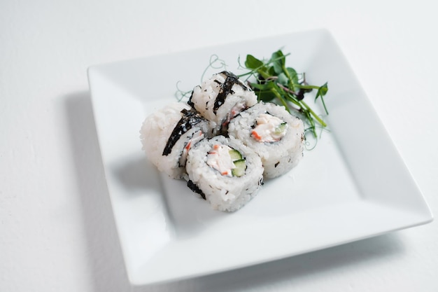 Cztery rolki maki sushi ozdobione zielenią