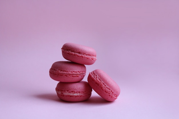 Cztery różowego macaroons na świetle - różowy tło, słodki minimalny karmowy pojęcie