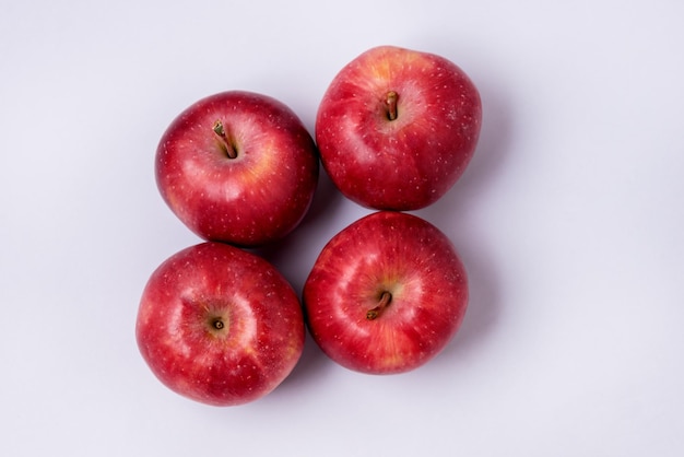 Cztery smaczne czerwone jabłka na niebieskim tle Widok z góry poziomo