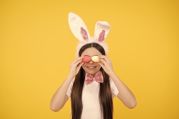 Czując radość, uśmiechnięta nastolatka w muszce króliczka poluje na jajka, po prostu dobrze się bawiąc, gotowa na imprezę