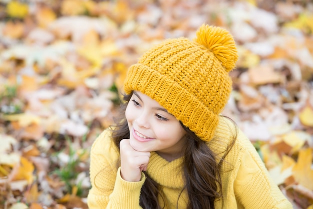 Czuję się wolny i zrelaksowany. jesień moda z dzianiny. romantyczny sezon na inspirację. szczęśliwe dzieciństwo. dziewczyna zrelaksować się w parku. piękno jesieni. ciesz się dniem w lesie. uśmiechnięte dziecko w kapeluszu zrelaksować się na świeżym powietrzu.