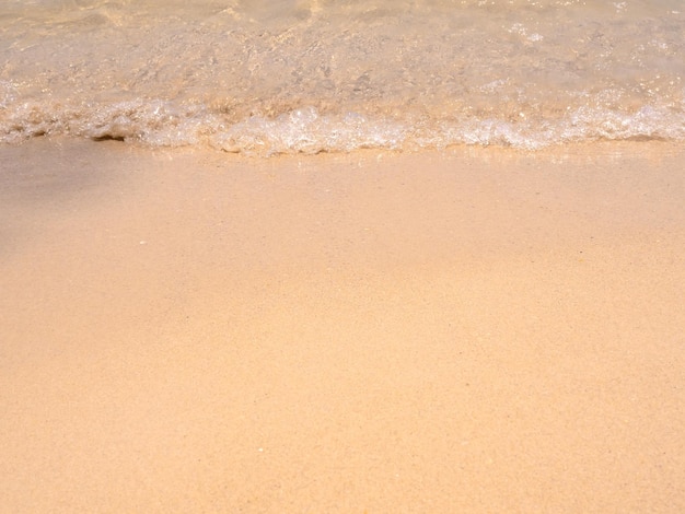 Czyste puste tło plaży ruch czystej wody morskiej i fala surfowania na piaszczystej plaży oceanu wybrzeże zbliżenie linii brzegowej widok z góry plaża z miejsca kopiowania letnie wakacje wakacje plakat tło