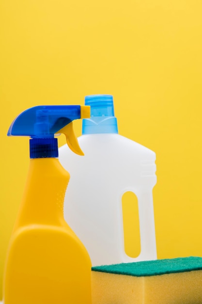 Czyszczenie butelek i ściereczek z rozpylaczem na jasnożółtym tle