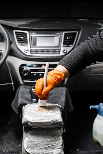 Czyszczenie chemiczne szczotką deski rozdzielczej w samochodzie Usługa auto detailingu Czyszczenie poszczególnych elementów wnętrza w samochodzie