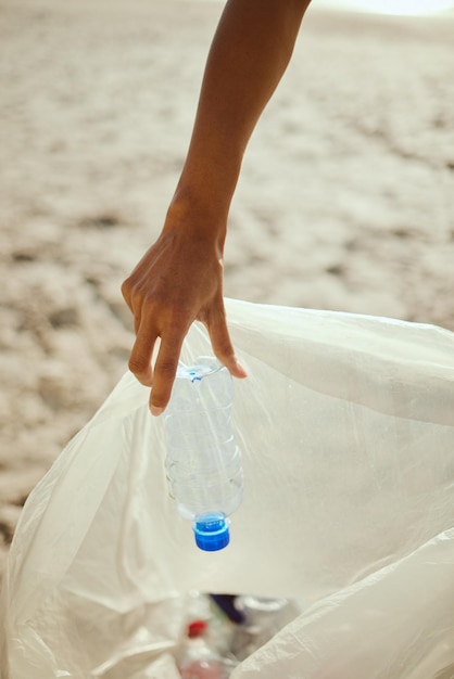 Czyszczenie plastiku i rąk wolontariusza na plaży w celu recyklingu środowiska lub dnia ziemi Recykling zrównoważonego rozwoju i zmiany klimatu z osobą charytatywną i workiem na śmieci w celu zanieczyszczenia i przyjaznego dla środowiska