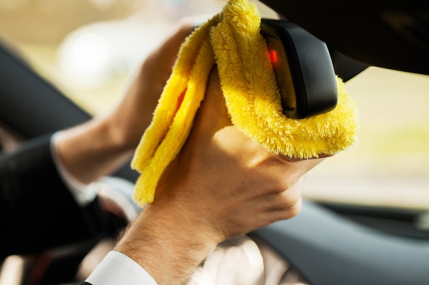 Zdjęcie czyszczenie samochodu. ręka z ściereczką z mikrofibry do czyszczenia wnętrza samochodu