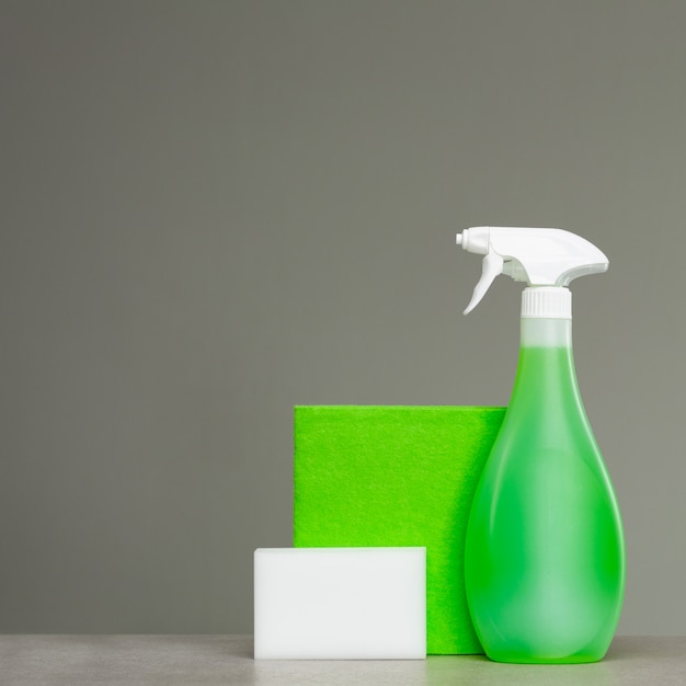 Zdjęcie czyszczenie zielonej butelki z rozpylaczem z plastikowym dozownikiem, gąbką i szmatką na kurz
