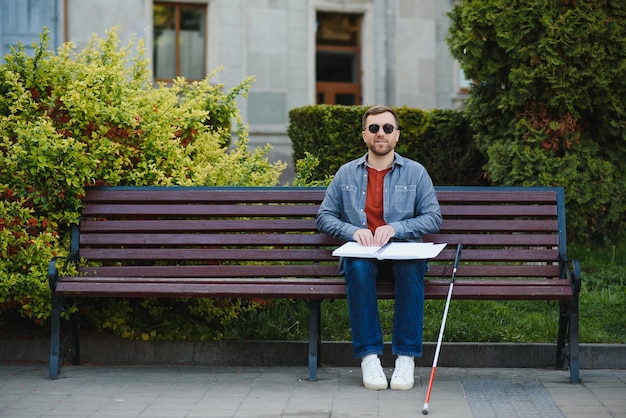 Czytający niewidomy mężczyzna dotykając książki Braille'a