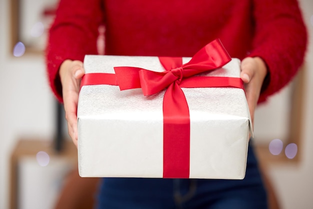 Czyż nie zapominamy o prawdziwym znaczeniu Bożego Narodzenia Ujęcie nierozpoznawalnej kobiety otwierającej prezenty podczas świąt w domu?