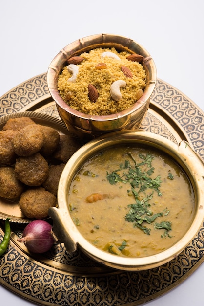 Daal Baati Churma to popularna zdrowa żywność z Radżastanu w Indiach. Podawane w białych naczyniach na nastrojowym tle.