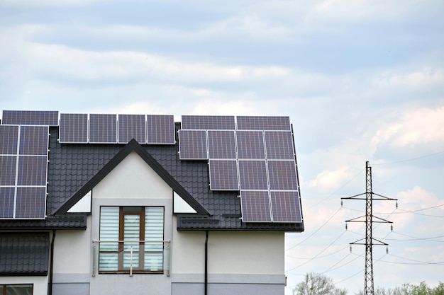 Dach prywatnego domu pokryty panelami fotowoltaicznymi do wytwarzania czystej, ekologicznej energii elektrycznej na podmiejskiej wsi Koncepcja domu autonomicznego