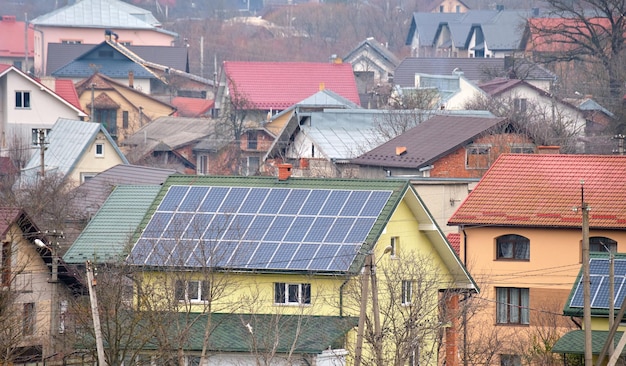 Dach prywatnego domu pokryty panelami fotowoltaicznymi do wytwarzania czystej, ekologicznej energii elektrycznej na podmiejskiej wsi Koncepcja domu autonomicznego