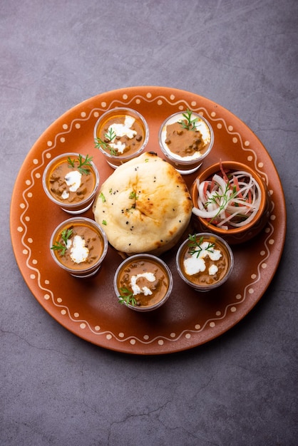 Dal Makhani lub dal makhni Shoty z masłem z fasoli Naan i śmietaną podawane z czosnkiem naan lub indyjskim chlebem lub roti