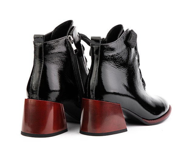 Damskie jesienne czarne skórzane buty do kostek z czarnym zamkiem i średnimi czerwonymi obcasami na białym tle Widok z tyłu Modne buty
