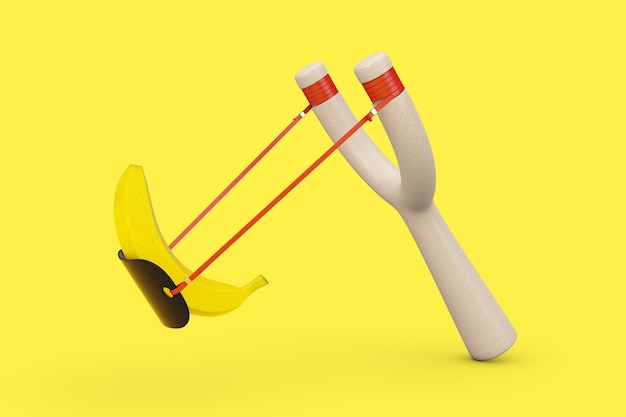 Danger Wooden Slingshot Toy Weapon z dojrzałymi żółtymi owocami bananowymi na żółtym tle. Renderowanie 3D