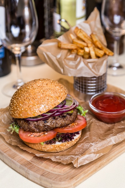 Danie w restauracji - burger z kotletem z patelni ziemniaczanej na desce