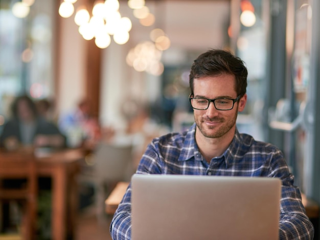 Darmowe wifi Nie przejmuj się, jeśli to zrobię Zdjęcie młodego mężczyzny korzystającego z laptopa podczas siedzenia w kawiarni?