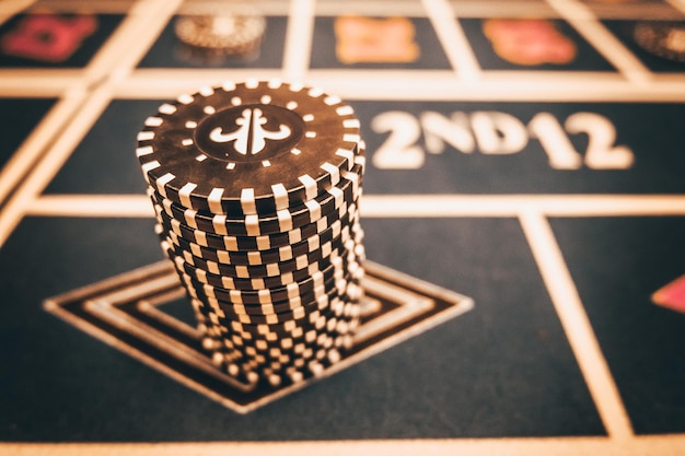 Zdjęcie dealer lub krupier miesza karty pokerowe w kasynie na tle żetonów stołowych